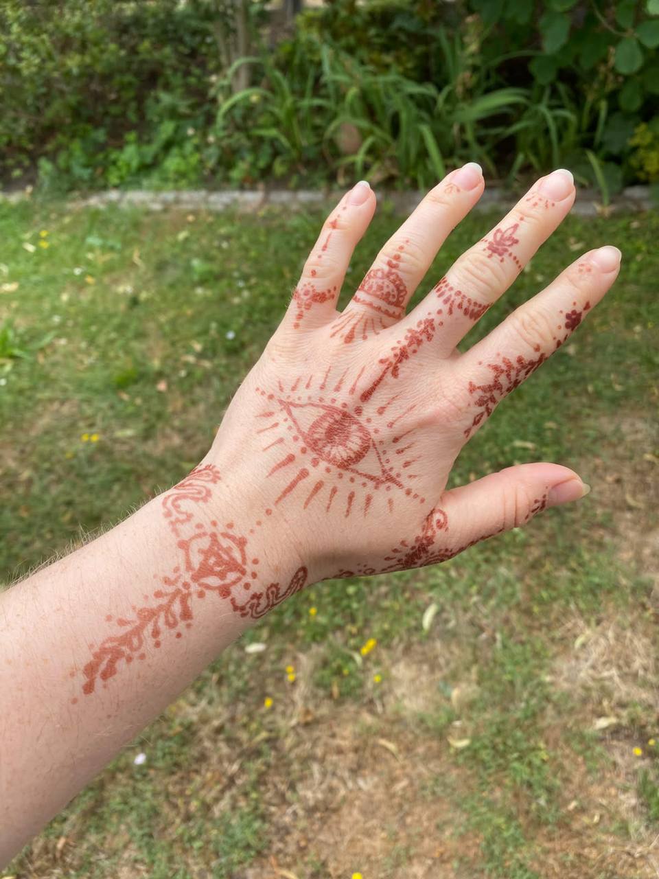 Hand mit Henna-Ornamenten und einem Auge auf dem Handrücken